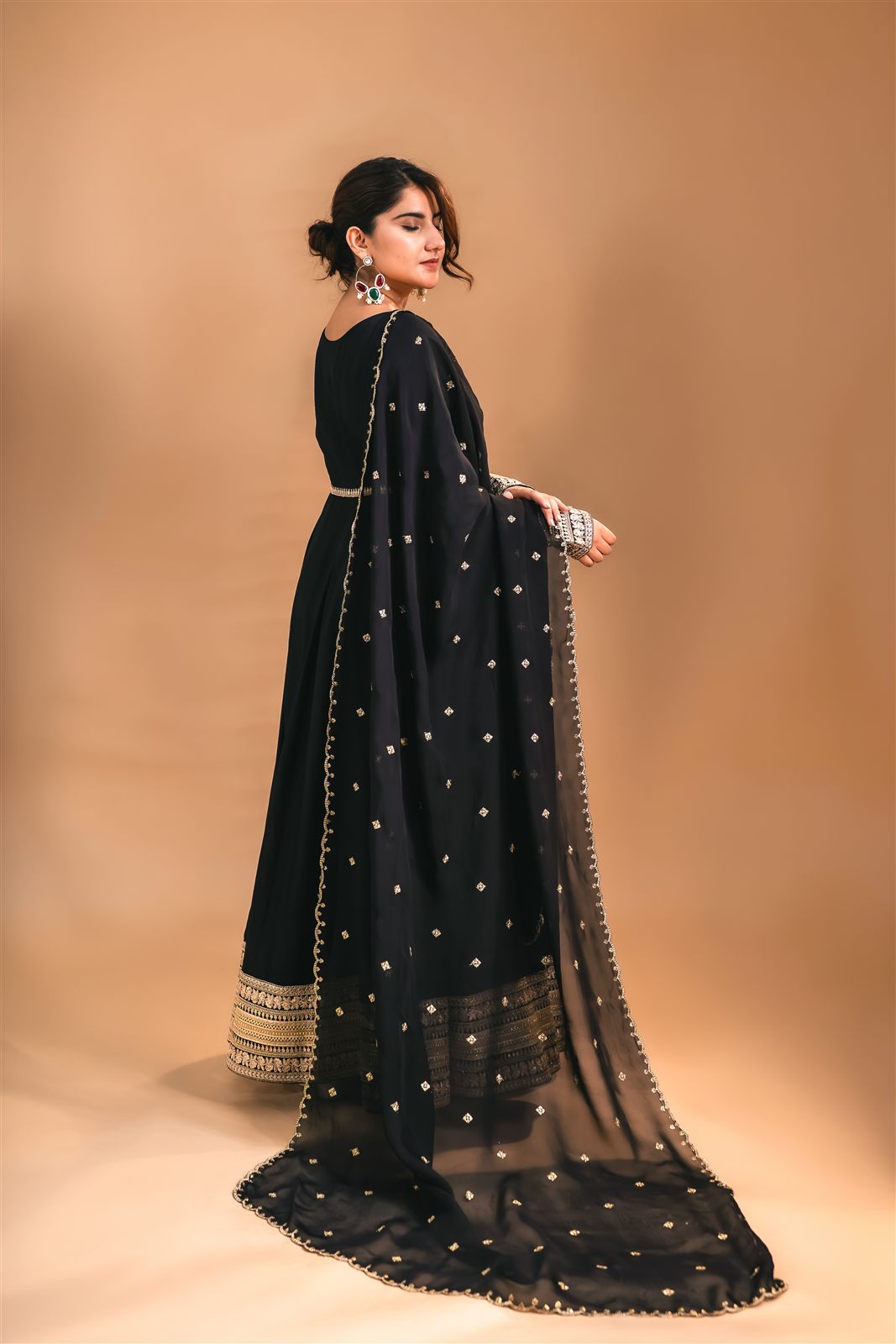 Black gown with gold-embellished dupatta, side profile